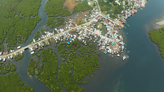 City in wetlands and mangroves on the ocean coastline aerial view. Siargao island, Philippines.