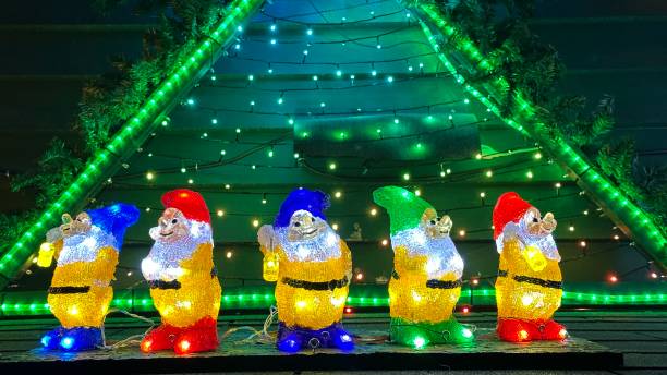 istock Illuminated Christmas gnomes standing in front of a christmas tree shape 1452513096