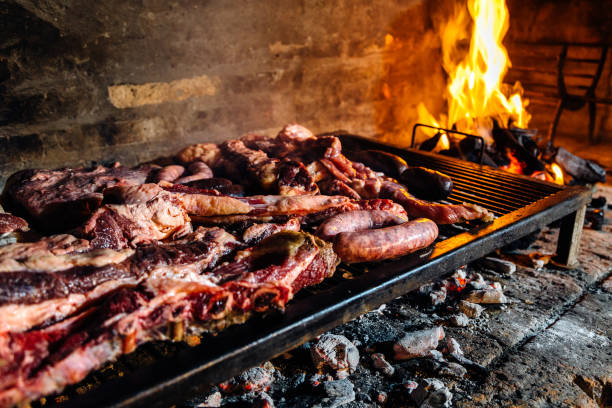 grill, grillfleisch kochen auf dem grill. traditionelles asado aus argentinien, paraguay und uruguay. - steak argentina food silverware stock-fotos und bilder