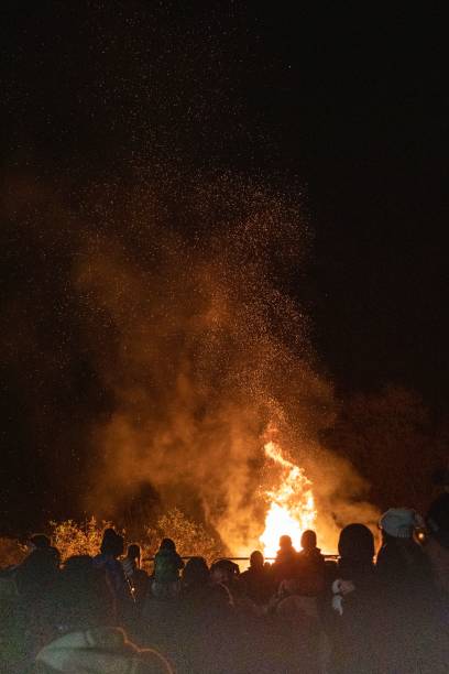 istock Vertical view of the crowd standing before the roaring bonfire flames at night 1452515138