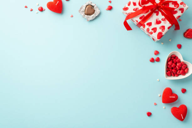 koncepcja walentynkowa. top view zdjęcie prezentu, świeczek w kształcie serca, cukierków i spodka z posypką na izolowanym jasnoniebieskim tle z pustą przestrzenią - valentines day candy chocolate candy heart shape zdjęcia i obrazy z banku zdjęć