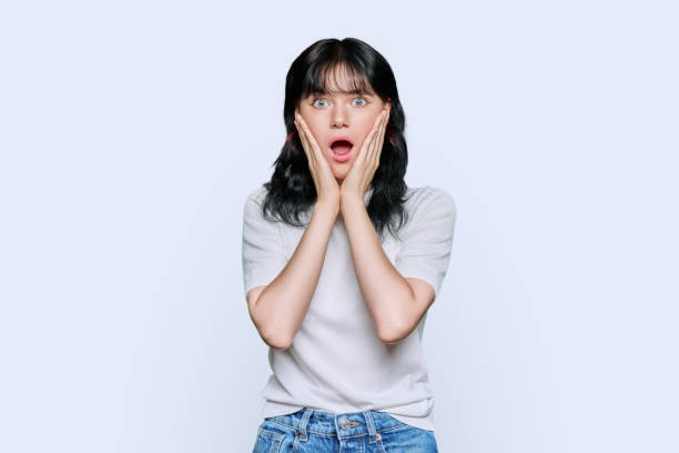 istock Young shocked woman looking at camera on white background 1452516954