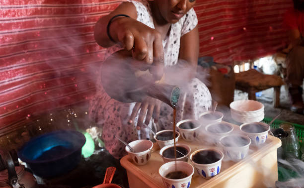 le donne versano il caffè bunna alla cerimonia tradizionale del caffè di addis abeba etiopia, africa - ethiopian people foto e immagini stock