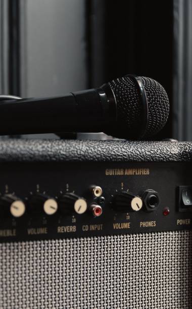 istock Vertical closeup shot of a microphone on a retro guitar amplifier in a studio 1452518891
