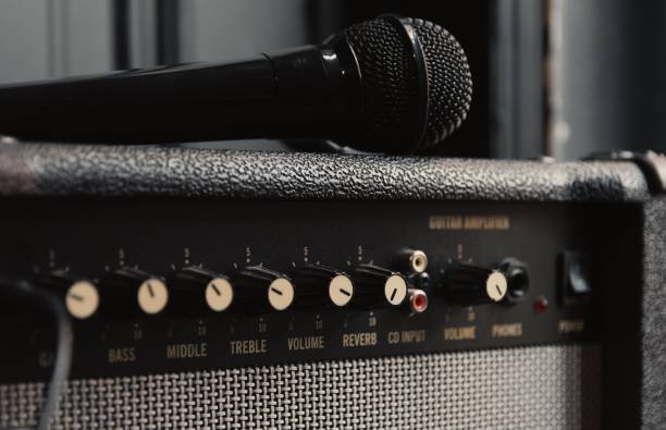 A closeup shot of a microphone on a retro guitar amplifier in a studio