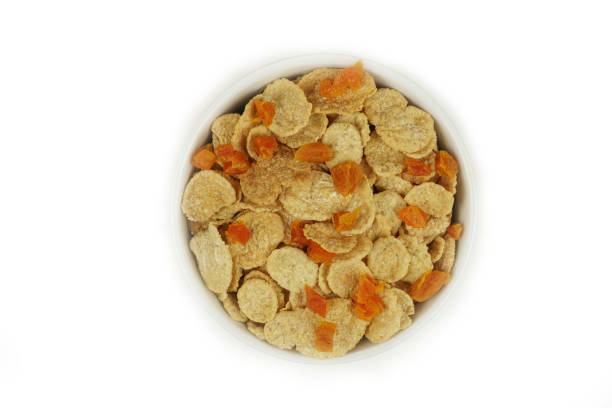 A bowl of cornflakes with dried apricots, top view. Isolated. High quality photo