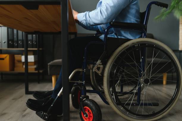 istock Man in wheelchair at home or in office. 1452528070