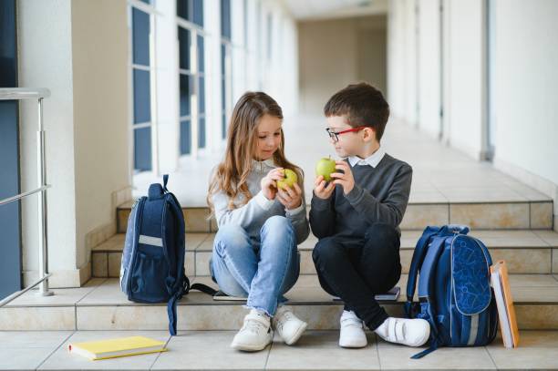 istock Happy school kids in corridor at school 1452530386