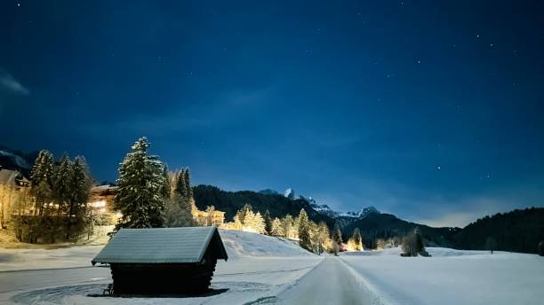 A tranquil and beautiful winter morning in the Engadine region of the Swiss Alps featuring a small wooden hut surrounded by deep snow and a breathtaking mountain panorama in the background. The soft light and calm atmosphere create a peaceful alpine mood, perfect for themes such as Swiss tourism, winter travel and natural beauty