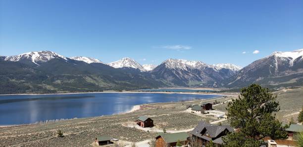 istock Panoramic shot of the small river between the snow-covered mountains against a blue sky 1452531789
