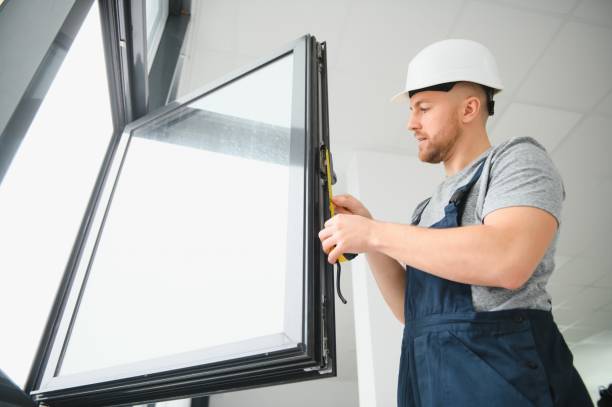 istock Workman in overalls installing or adjusting plastic windows in the living room at home 1452534588