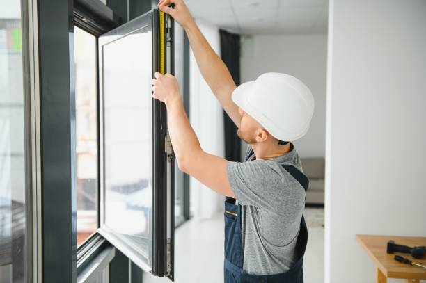 joven guapo instalando ventanal en el sitio de construcción de una nueva casa - window frame fotos fotografías e imágenes de stock