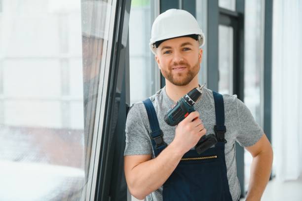istock Workman in overalls installing or adjusting plastic windows in the living room at home 1452534809