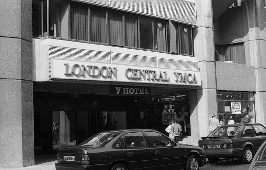 London, England - March 31, 1990: People stand by the Tottenham Court Road entrance of the London Central YMCA. The organisation was founded in 1844.