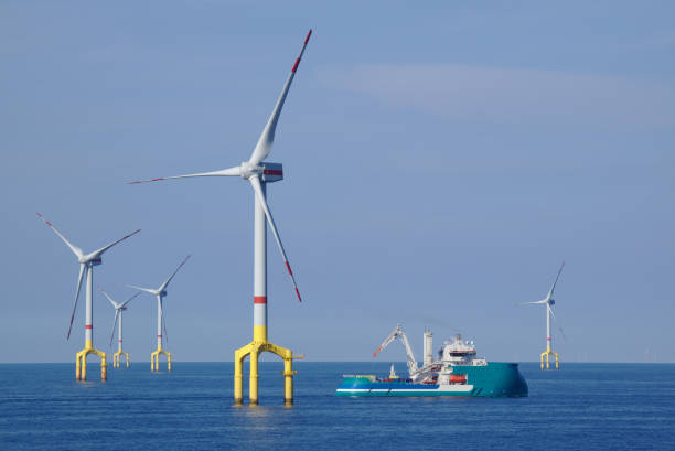 offshore wind turbine with supply boat offshore wind turbine field with supply boat navigation offshore wind farm stock pictures, royalty-free photos & images