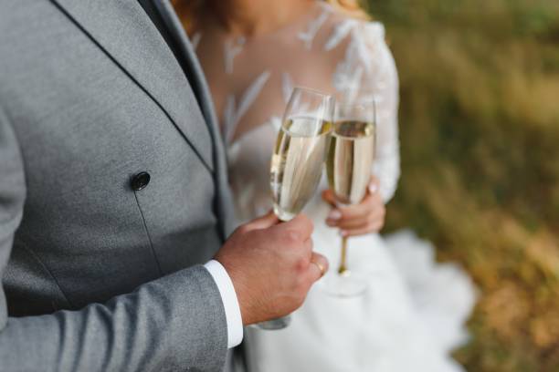 hands of bride and groom holding champagne glasses with sparkling wine. wedding celebration concept. - women bride personal accessory adult imagens e fotografias de stock