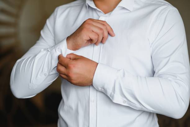 istock A man fastens buttons on his shirt. 1452537367