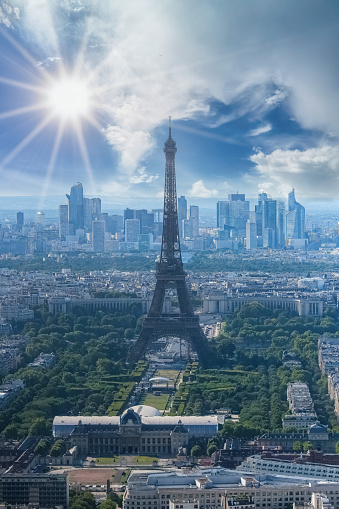 Paris, aerial view of the Eiffel Tower in backlight, sun star, with the Defense towers in background