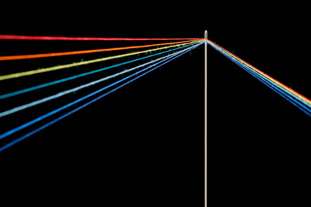 istock multi-colored threads for sewing in the form of a rainbow pass through an antique needle on a black background 1452543327