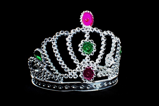 A princess silver tiara with colorful stones isolated on a black background