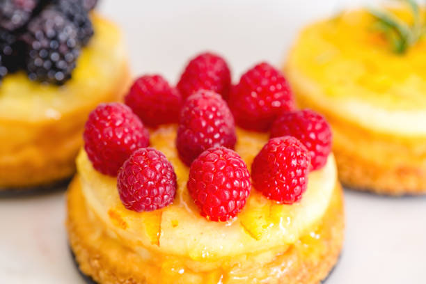 Cheesecakes with berries and orange jelly close-up. Mini cheesecakes with different types of toppings recipe