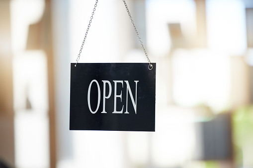 Small business, cafe and advertising with open sign for marketing, board or start of opening hours. Welcome, entrance and door of startup shop, restaurant or store in window of retail coffee shop