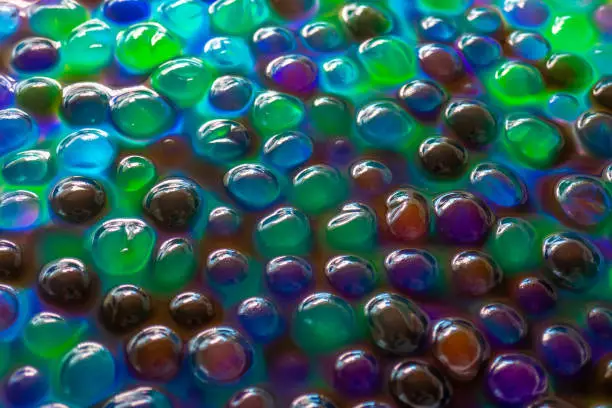 Hydrogel Orbeez background.Blue green orbiz balls in water.Hydrogel balls for decoration, gardening and air humidifier.Beautiful background in cool colors.multicolored orbiz texture.