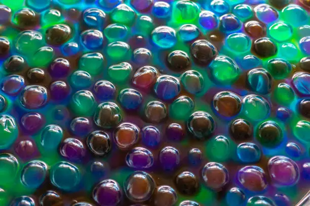 Hydrogel Orbeez background.Blue green orbiz balls in water.Hydrogel balls for decoration, gardening and air humidifier.background in cool colors.multicolored orbiz texture.