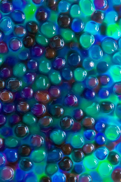 Hydrogel Orbeez background.multicolored orbiz texture.Blue green orbiz balls in water.Hydrogel balls for decoration, gardening and air humidifier.