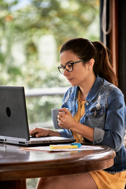 Close-up of Hispanic young beautiful businesswoman working on her computer at home office stock photo