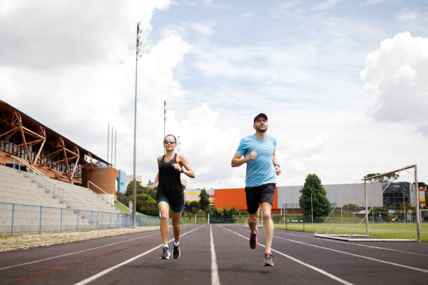 istock Couple running together through the running field 1452554177