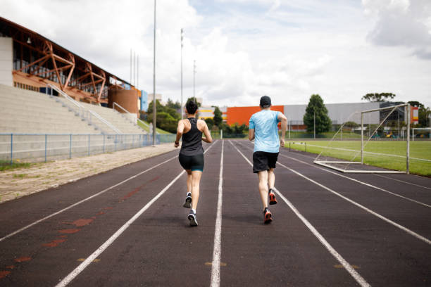 istock Couple running together through the running field 1452554181