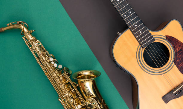 istock Guitar and saxophone on paper background, top view. 1452554331