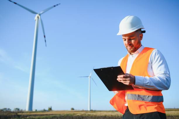istock Electrical engineers working at wind turbine power generator station with laptop computer 1452556123