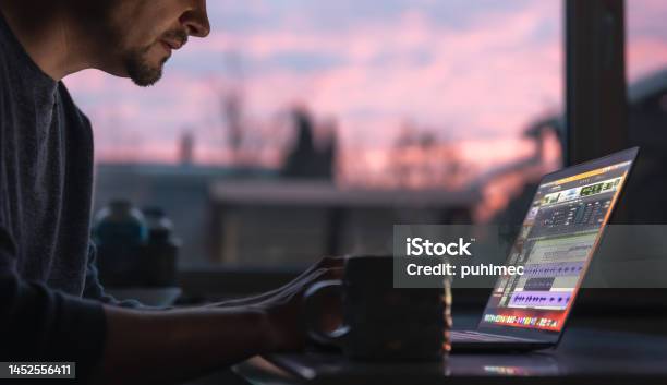 A Man Works With Sound On A Laptop Early In The Morning Stock Photo - Download Image Now