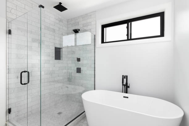 un bagno con vasca autoportante e doccia piastrellata in marmo. - standalone foto e immagini stock
