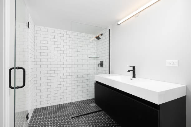 istock A bathroom with a black cabinet, white sink, and subway tile shower. 1452561476