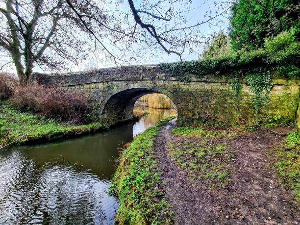 istock Horizontal view of a stone bridge and river passing through it surrounded by green nature in a park 1452562188