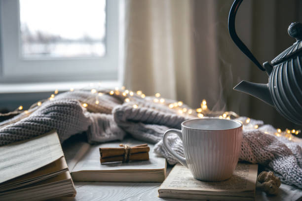 istock Cozy composition with a teapot, a cup and a book on a blurred background. 1452562327