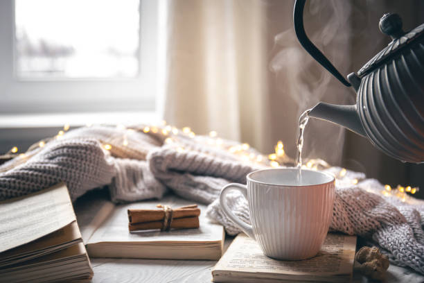 istock Cozy composition with a teapot, a cup and a book on a blurred background. 1452562329