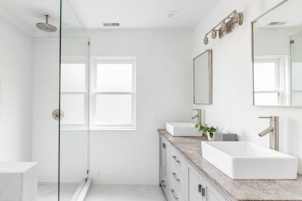 istock A luxury bathroom with a grey cabinet, granite countertop, and white tiled shower. 1452564497