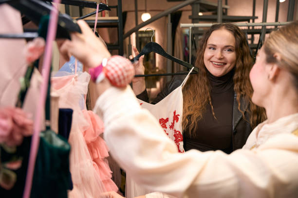 istock Two smiling women in design studio reviewing dresses 1452566883