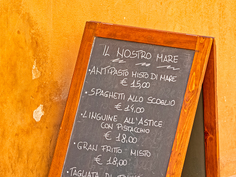 Restaurant menu sign found along the streets in of Volterra in the Tuscany region of Italy