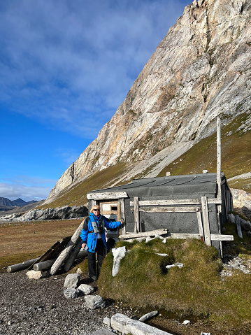 Single woman visiting a historic  trapper's cabin on Svalbard