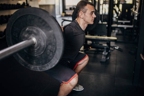 istock Young man weightlifting in gym 1452574178