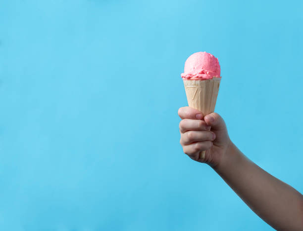 istock berry ice cream in a waffle cup a child holds a cone in his hand 1452577685