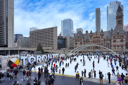 Toronto, Canada - December 26, 2022:  The free skating rink at City Hall square is a popular attraction, with skate rentals available.