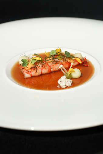 Michelin star gourmet dish with prawn in seafood consomme with horseradish