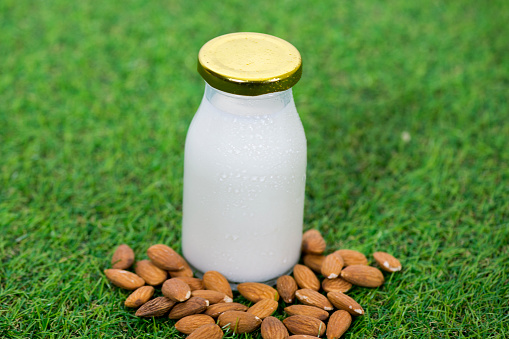Closeup of a small glass bottle of homemade almond nut milk as part of a vegan diet.
