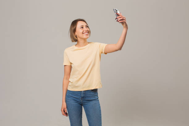 istock Blonde woman with mobile phone in studio on white background 1452586167